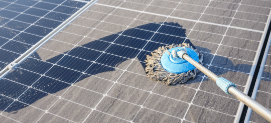 Limpiar el polvo de los paneles solares en una granja solar