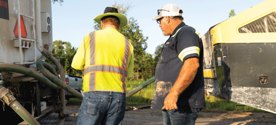 Dos empleados de obras públicas preparándose para aplicar Perma-Zyme