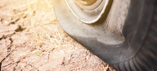Neumático desinflado para equipos pesados ​​en una carretera seca y sin pavimentar